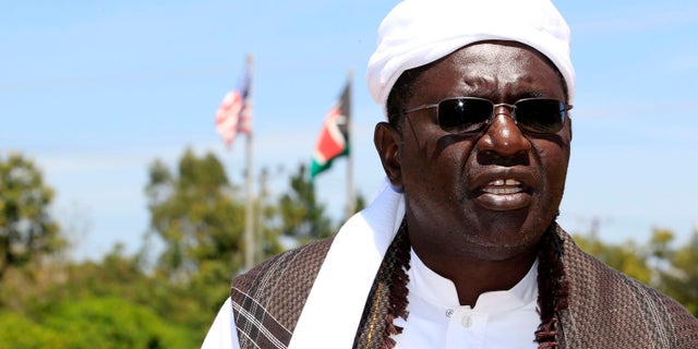 Malik Obama, half-brother of President Barack Obama, talks to a polling official in the village of Nyangoma Kogelo, during elections there on March 4, 2013. (REUTERS/Thomas Mukoya)
