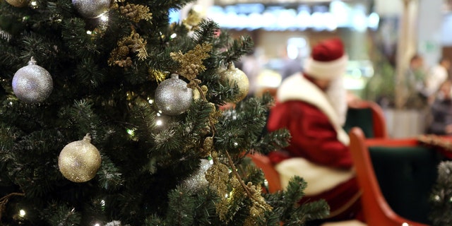 Santa Claus in Shopping Center on defocused lights background