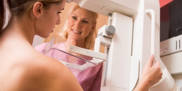 Nurse Assisting Patient Undergoing Mammogram