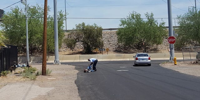 David Lee Witherspoon Jr., bent down to help man put on shoes. Captured by Lee Henry, Kitchen Manager of the St. Vincent de Paul food pantry in Phoenix.