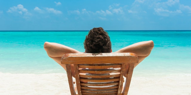 Man relaxing on beach, ocean view, Maldives island
