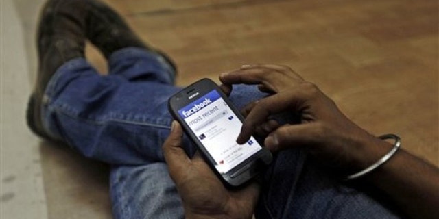 May 18, 2012: A man surfs the Facebook site on his mobile phone.
