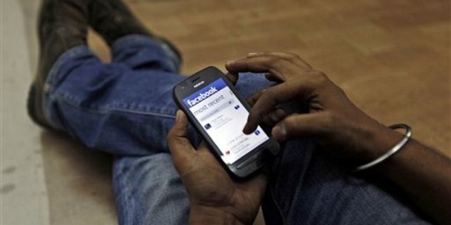 May 18, 2012: A man surfs the Facebook site on his mobile phone.
