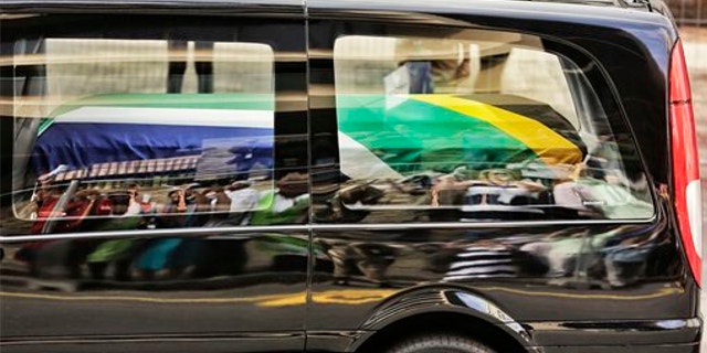 Dec. 11, 2013: People are reflected in the car carrying former South African president Nelson Mandela as it makes its way through the streets of Pretoria, South Africa.