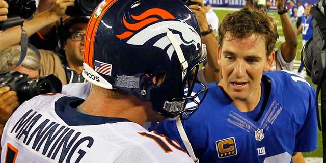 Denver Broncos quarterback Peyton Manning (L) talks with his brother, New York Giants quarterback Eli Manning after the Broncos defeated the Giants in their NFL football game in East Rutherford, New Jersey, September 15, 2013. REUTERS/Gary Hershorn (UNITED STATES - Tags: SPORT FOOTBALL) - RTX13MSZ