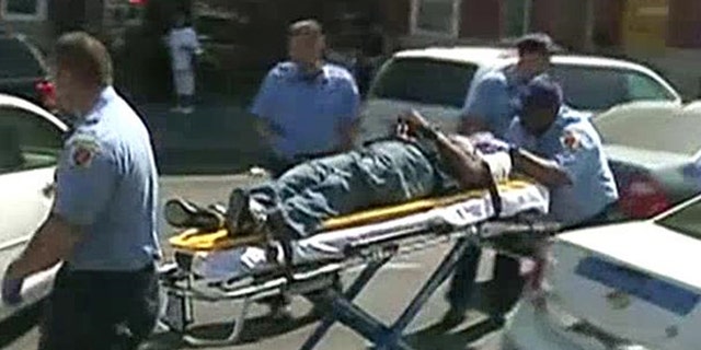 The unidentified man is seen in a stretcher after gunfire was heard Monday in Baltimore, Md.