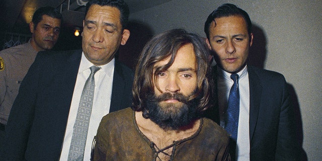 In this 1969 file photo, Charles Manson is escorted to his arraignment on conspiracy-murder charges.