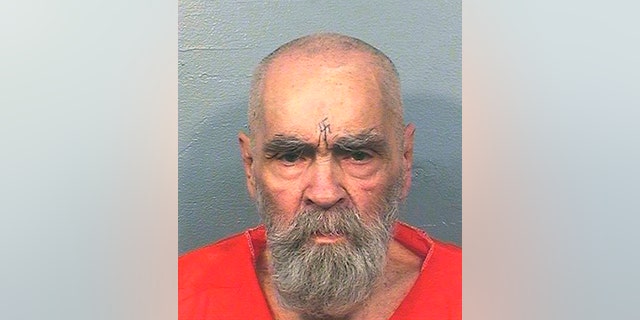 Charles Manson in prison with a swastika carved into his forehead.