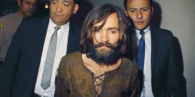 FILE - In this 1969 file photo, Charles Manson is escorted to his arraignment on conspiracy-murder charges in connection with the Sharon Tate murder case. Authorities say Manson, cult leader and mastermind behind 1969 deaths of actress Sharon Tate and several others, died on Sunday, Nov. 19, 2017. He was 83. (AP Photo, File)