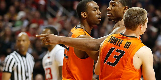 Feb. 8, 2014: Oklahoma State's Markel Brown (22) and Phil Forte (13) hold Marcus Smart (33) after Smart shoved a fan during their NCAA college basketball game in Lubbock, Texas.