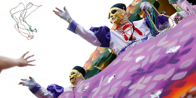 File - Mardi Gras beads are tossed at partygoers.