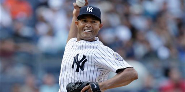 New York Yankees relief pitcher Mariano Rivera (42) throws to first on a pickoff move in the eighth inning of a baseball game against the San Francisco Giants in New York.