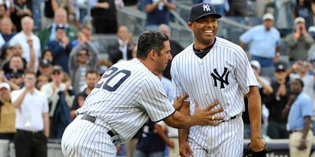 Sept 19: New York Yankees Jorge Posada pushes Mariano Rivera, right, back to the mound to acknowledge the cheers of the crowd after Rivera recorded his 602nd save as the Yankees beat the Minnesota Twins 6-4 on Monday, Sept. 19, 2011, at Yankee Stadium.