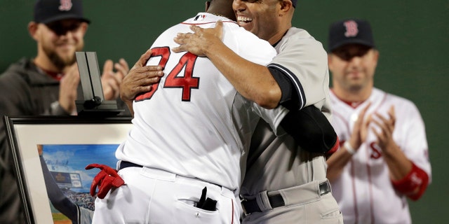 New York Yankees relief pitcher Mariano Rivera, right, hugs Boston Red Sox's David Ortiz during a tribute for Rivera before the start of a baseball game at Fenway Park, in Boston, Sunday, Sept. 15, 2013.