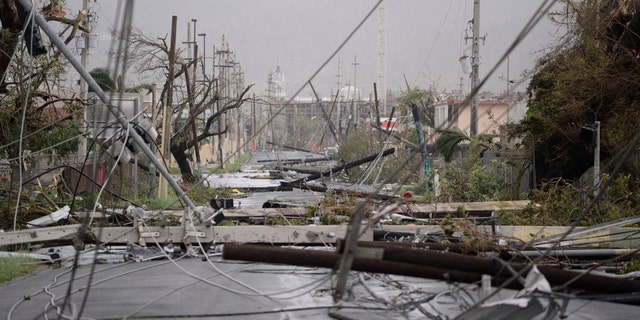 Electricity poles and lines lay toppled on the road after Hurricane Maria hit the eastern region of the island, in Humacao, Puerto Rico, Wednesday, Sept. 20, 2017. The strongest hurricane to hit Puerto Rico in more than 80 years destroyed hundreds of homes, knocked out power across the entire island and turned some streets into raging rivers in an onslaught that could plunge the U.S. territory deeper into financial crisis. (AP Photo/Carlos Giusti)