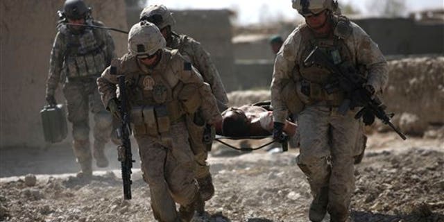 US Marines carry an injured Afghan soldier to a waiting medical evacuation helicopter, in Marjah, Helmand province, Afghanistan.