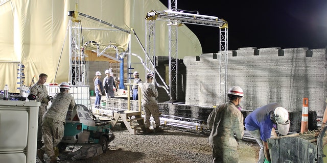 Marines from I Marine Expeditionary Force learn how to operate the world's largest concrete 3D printer as it constructs a 500-square-foot barracks hut at the U.S. Army Engineer Research and Development Center in Champaign, Illinois. (U.S. Marine Corps Courtesy Photo)