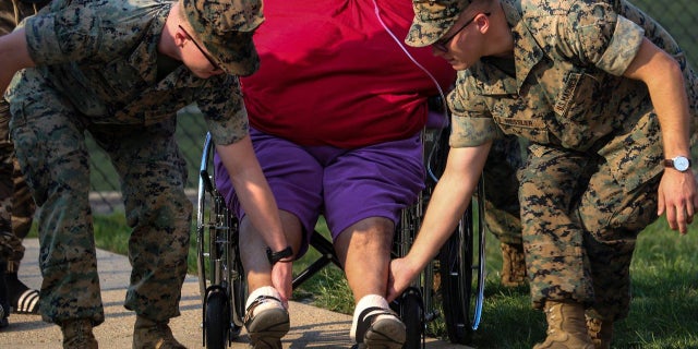 Marines can be seen helping residents of a senior housing apartment escape a fire that broke out Thursday afternoon.