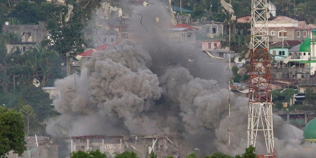 Debris fly as Philippine Air Force fighter jets bomb suspected locations of Muslim militants as fighting continues in Marawi city, southern Philippines, Friday, June 9, 2017.