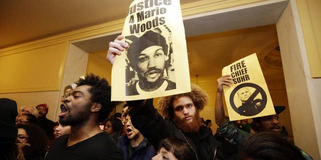 Demonstrators hold signs outside of a crowded San Francisco police commission hearing in December.