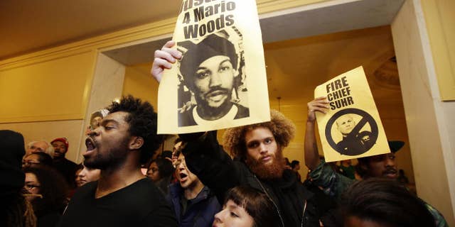 Demonstrators hold signs outside of a crowded San Francisco police commission hearing in December.