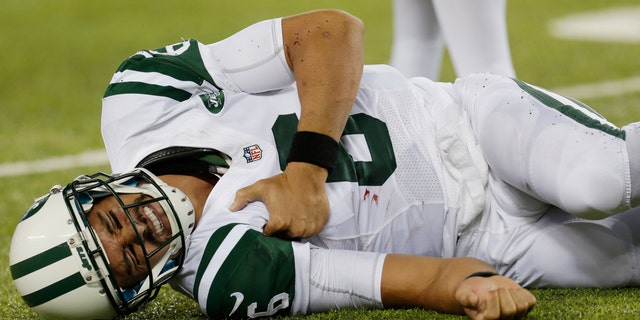 New York Jets quarterback Mark Sanchez (6) reacts to an injury during the second half of a preseason NFL football game against the New York Giants, Saturday, Aug. 24, 2013, in East Rutherford, N.J. He left the game with what appeared to be a shoulder injury. (AP Photo/Julio Cortez)