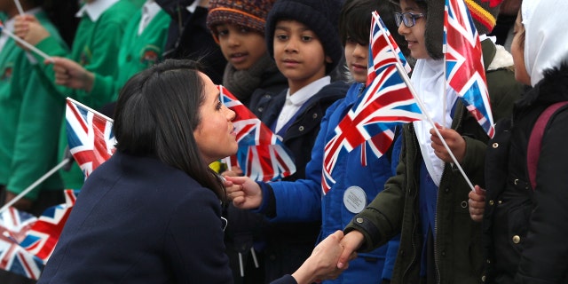 Meghan Markle talks to local school children during a walkabout with Britain's Prince Harry during a visit to Birmingham, Britain, March 8, 2018.