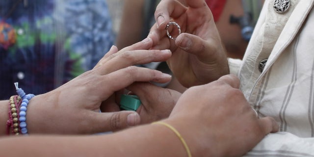 September 2, 2015– Groom places a ring on bride’s finger at a wedding ceremony in Nevada. (REUTERS)
