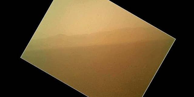 This photo taken by NASA's Mars rover Curiosity shows the north wall and rim of Gale Crater. The image is the first color photo snapped by Curiosity's Mars Hand Lens Imager (MAHLI) on the afternoon of the first day after landing. NASA released