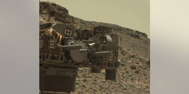 This raw-color image captured by the Mars rover Curiosity's Mastcam shows the robot's drill just after finishing a drilling operation at an outcrop called Telegraph Peak on Feb. 24, 2015.