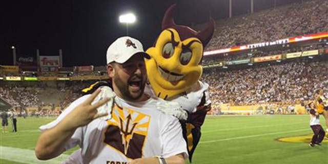 Sept. 18, 2015: This photo courtesy of David Schapira shows ASUs mascot Sparky jumping on David Schapira at a Arizona State University football game in Tempe, Ariz. Schapira, a Tempe City Councilman, has filed a claim against Arizona State University for injuries suffered when the school mascot leapt on him.