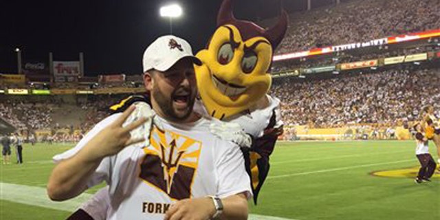 Sept. 18, 2015: This photo courtesy of David Schapira shows ASUs mascot Sparky jumping on David Schapira at a Arizona State University football game in Tempe, Ariz. Schapira, a Tempe City Councilman, has filed a claim against Arizona State University for injuries suffered when the school mascot leapt on him.