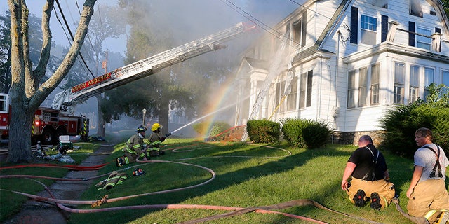 Firefighters battle a house fire in North Andover on Thursday.