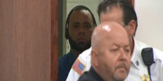 Angelo Colon-Ortiz stood behind a courtroom door during his arraignment on Wednesday.