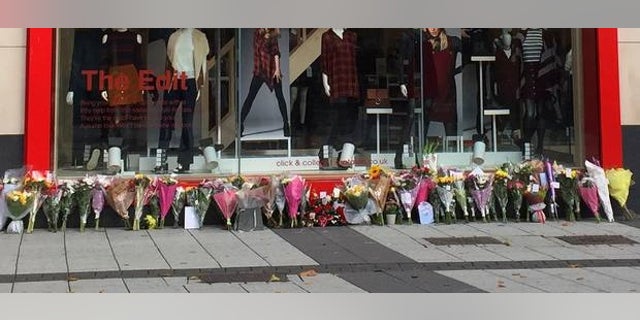 Flowers left outside the store where the couple worked, after the murders last September.