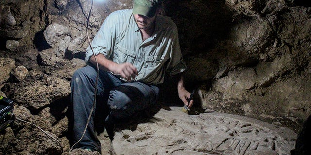 Tulane archaeologist Marcello A. Canuto sits beside the altar he and his team discovered in the jungles of northern Guatemala. (Photo courtesy of the National Museum of Archaeology and Ethnology in Guatemala City)