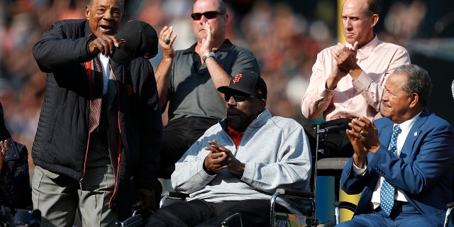 Former San Francisco Giants players Willie Mays, Will Clark, Kirk Rueter, Juan Marichal and Willie McCovey, clockwise from left, acknowledge fans during a ceremony to retire Barry Bonds' jersey number before a baseball game between the Giants and the Pittsburgh Pirates in San Francisco, Aug. 11, 2018.