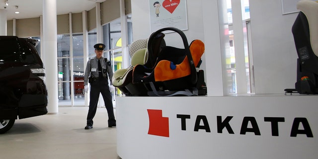 Nov. 6, 2014: A security guard stands by child seats, manufactured and displayed by Takata Corp. at an automaker's showroom in Tokyo.