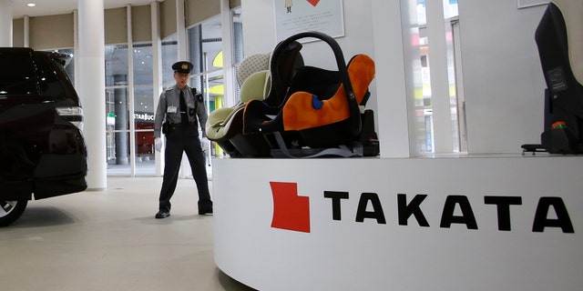 Nov. 6, 2014: A security guard stands by child seats, manufactured and displayed by Takata Corp. at an automaker's showroom in Tokyo.