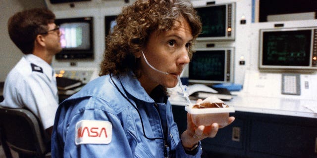 Christa McAuliffe, seen in 1985 taking a sip from a space-packaged drink prior to her ill-fated flight on space shuttle Challenger, was to teach from orbit. (NASA)