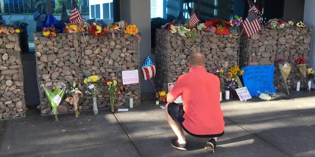 US Navy veteran pays his respects at memorial set up outside of Senator McCain's office