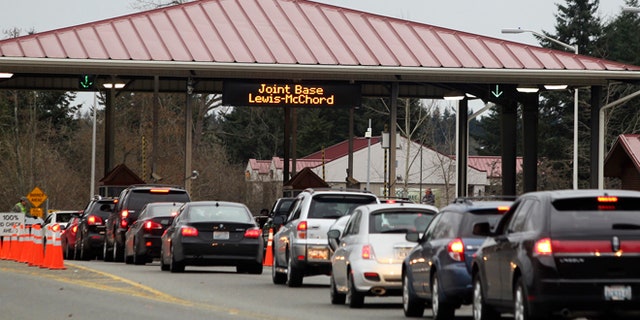 FILE: Commuters drive through the security checkpoint at the Madigan Army Hospital gate of Joint Base Lewis McChord (JBLM.)