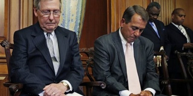FILE: Senate Minority Leader Mitch McConnell, R-Ky., and House Republican Leader John Boehner, R-Ohio, bow their heads in prayer as they participate in a ceremony on June 16 to unveil plaques recognizing the contributions of enslaved African Americans in the construction of the United States Capitol.