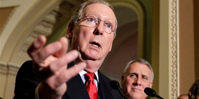 Senate Republican Leader Mitch McConnell gestures while speaking with reporters following a weekly Republican policy luncheon June 28 on Capitol Hill.