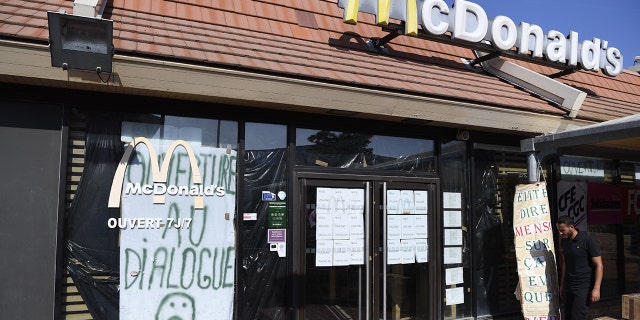 An employe of McDonald's Saint Barthelemy, on strike since the beginning of August, walks in front of the closed restaurant in the northern neighborhood of Marseille, southern France.