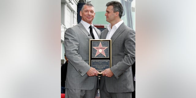 Vince McMahon (L), the chairman of World Wrestling Entertainment, Inc. holds a plaque as he poses with his son Shane after the former's Hollywood Walk of Fame star was unveiled in Hollywood, California March 14, 2008. REUTERS/Fred Prouser (UNITED STATES) - RTR1YB40