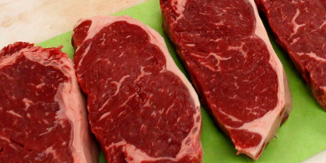 April 25, 2012: Strip steaks sit on the butchers table.