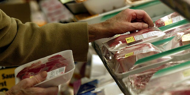 An unidentified shopper looks over the selection of steaks at local grocery store in Chicago. (Reuters)