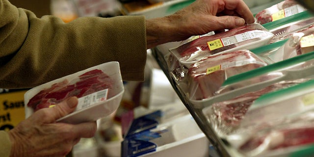 An unidentified shopper looks over the selection of steaks at local grocery store in Chicago. (Reuters)