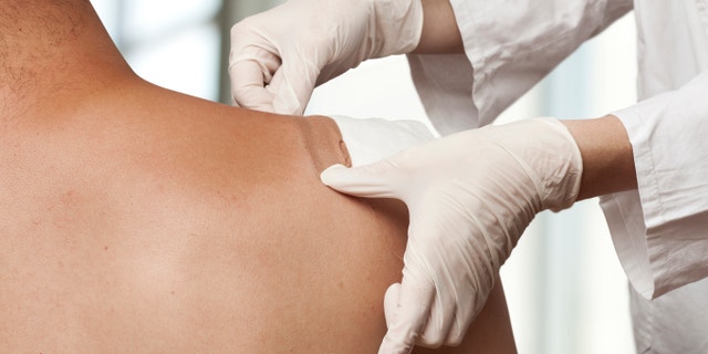Medical assistant changes the dressing of a wound at the emergency room